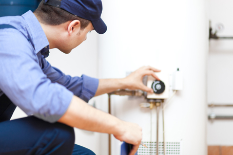 technician installing water heater in home